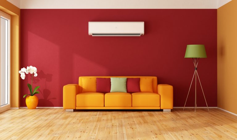 An air conditioning unit above a sofa in a colourful living room