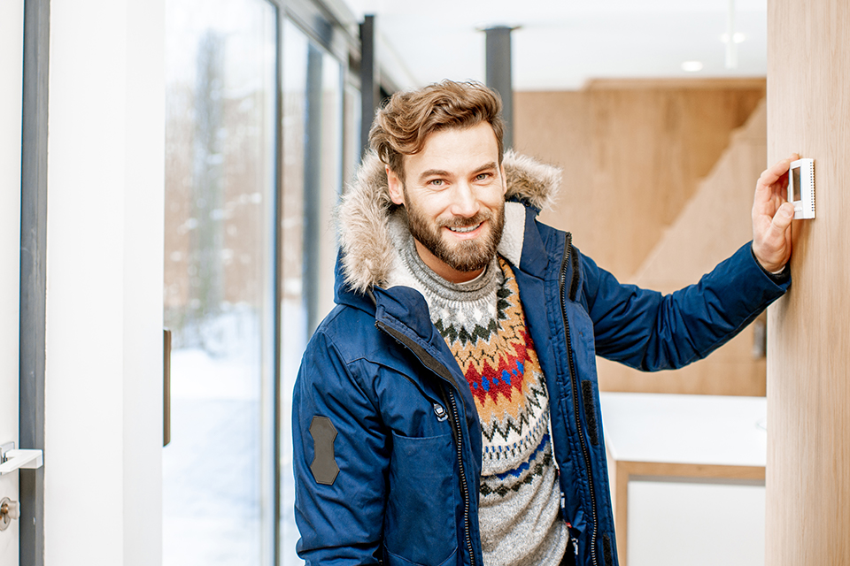 man adjusting thermostat