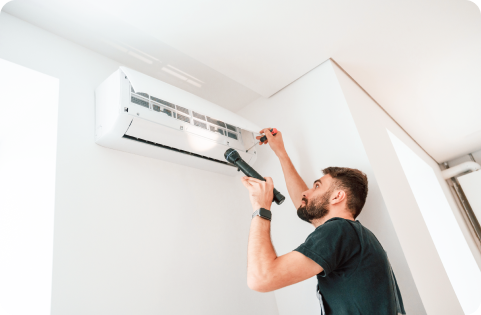 Man with torch servicing air-conditioning unit