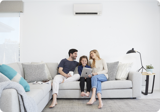 Family sitting in lounge under air conditioner