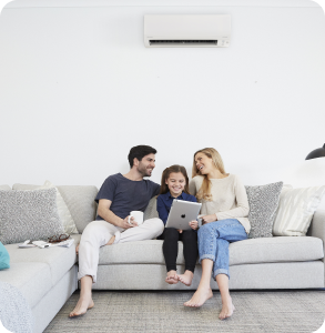 family sitting in living room enjoying split system airconditioner