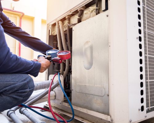 HVAC testing the pressure on an air conditioner unit