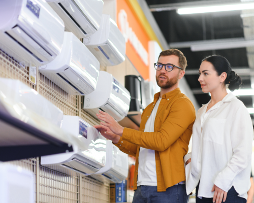Young couple choosing between air conditioning units